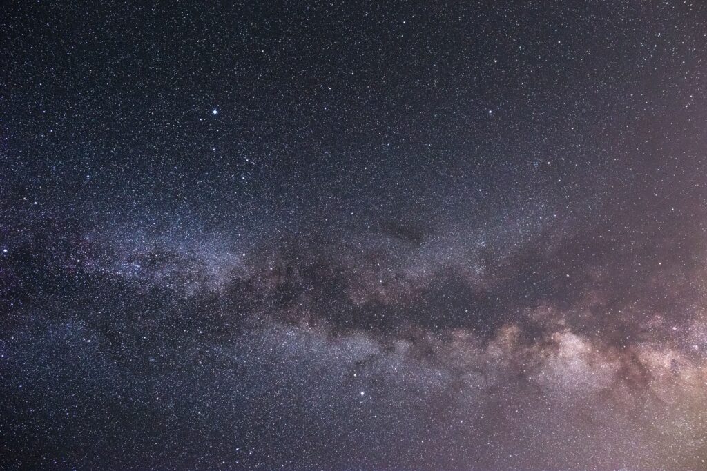 Star-filled night sky above a distant landscape