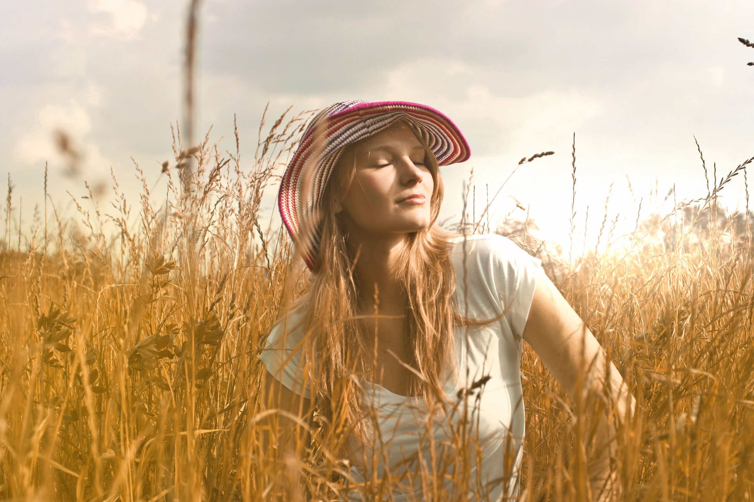 A woman enjoying the golden afternoon light in a peaceful meadow, reflecting warmth, serenity, and timeless harmony.