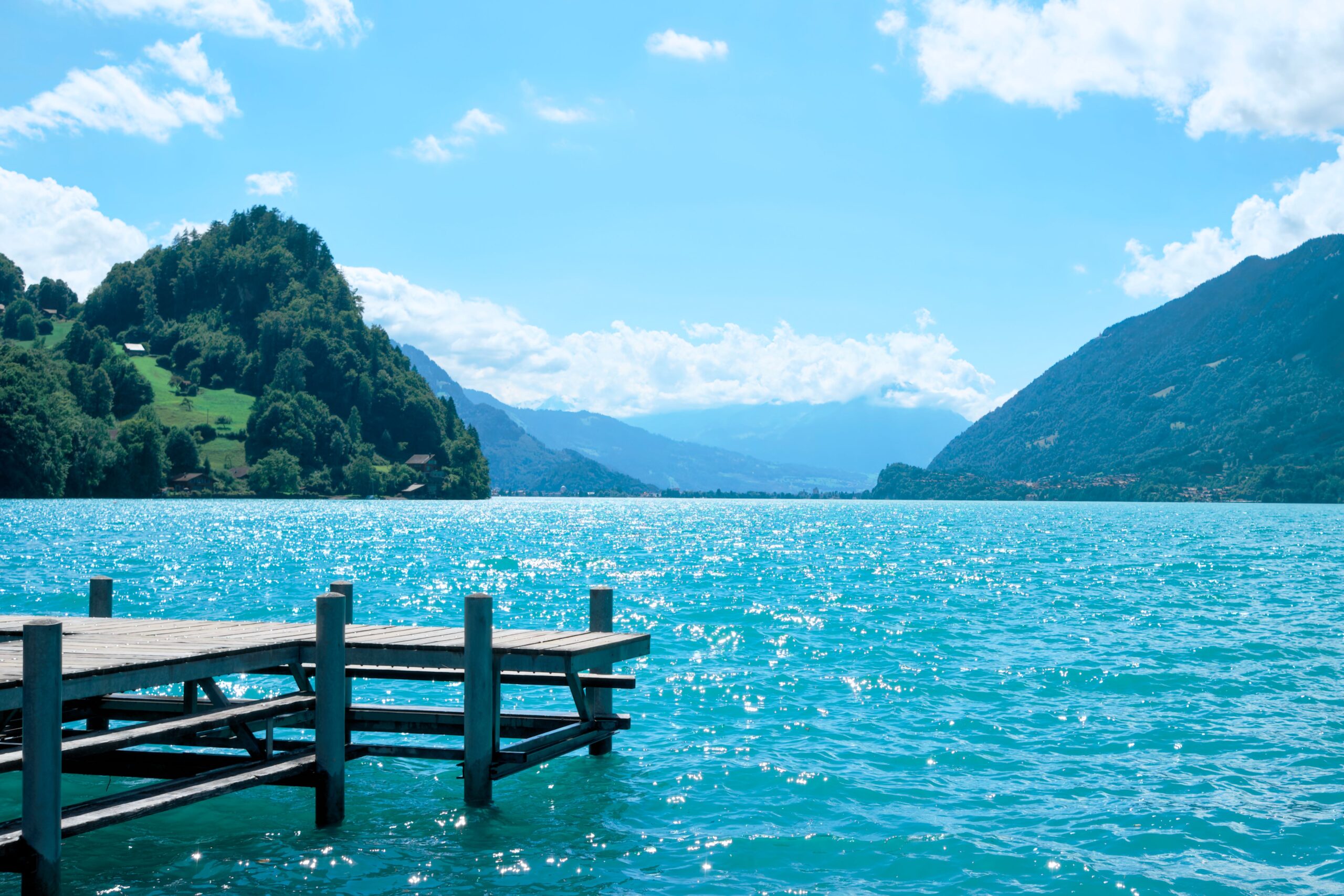 A peaceful lakeside pier surrounded by calm waters and distant mountains, inviting moments of relaxation, reflection, and quiet escape.