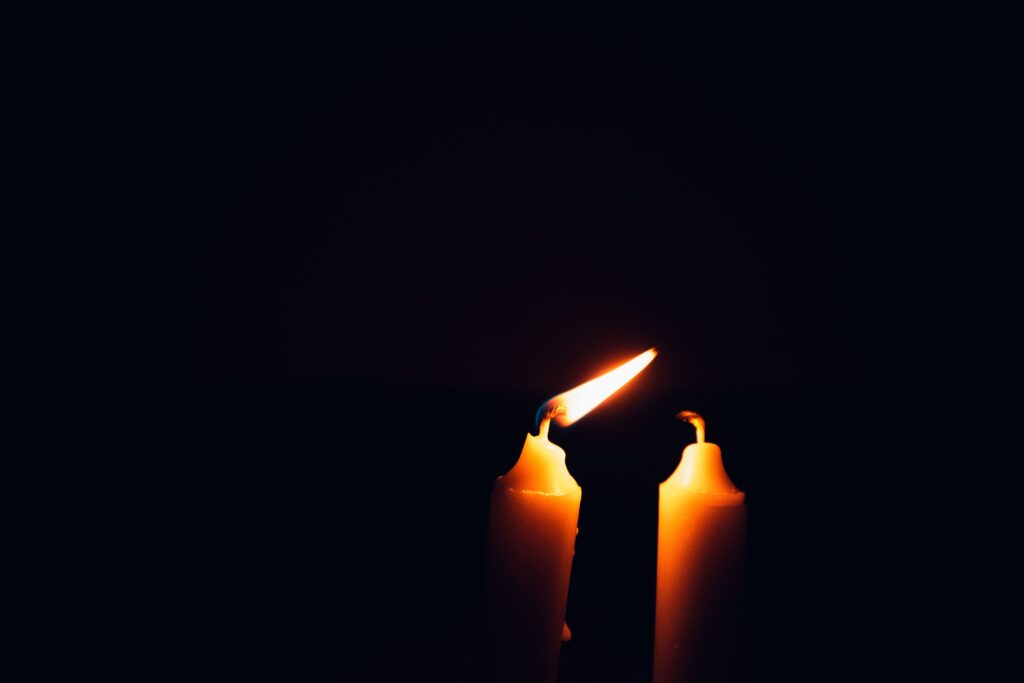 One candle lighting another, symbolizing continuity without an identical self