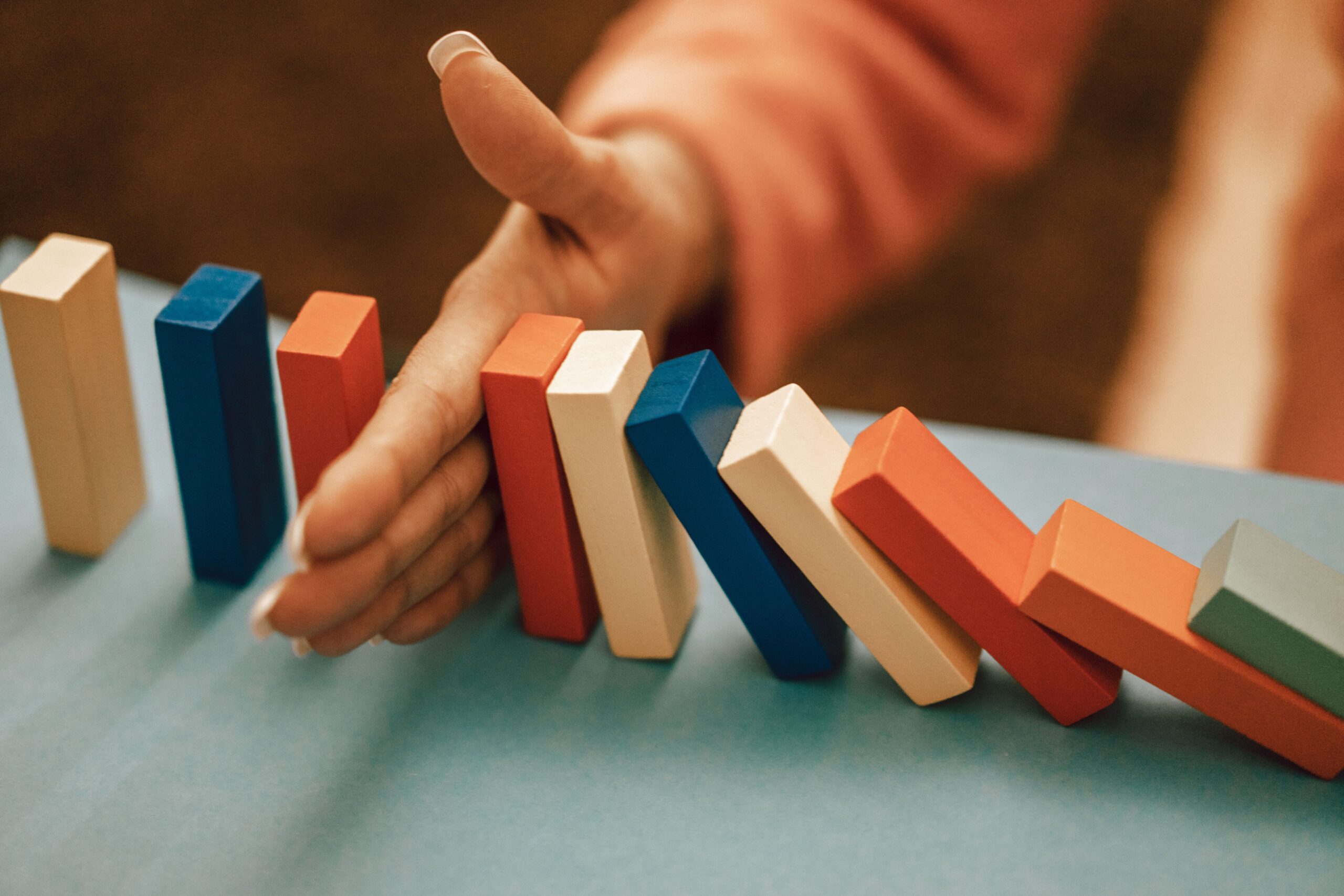 A chain of dominoes interrupted by a gap, symbolizing the unexplained connection between dependent origination and rebirth